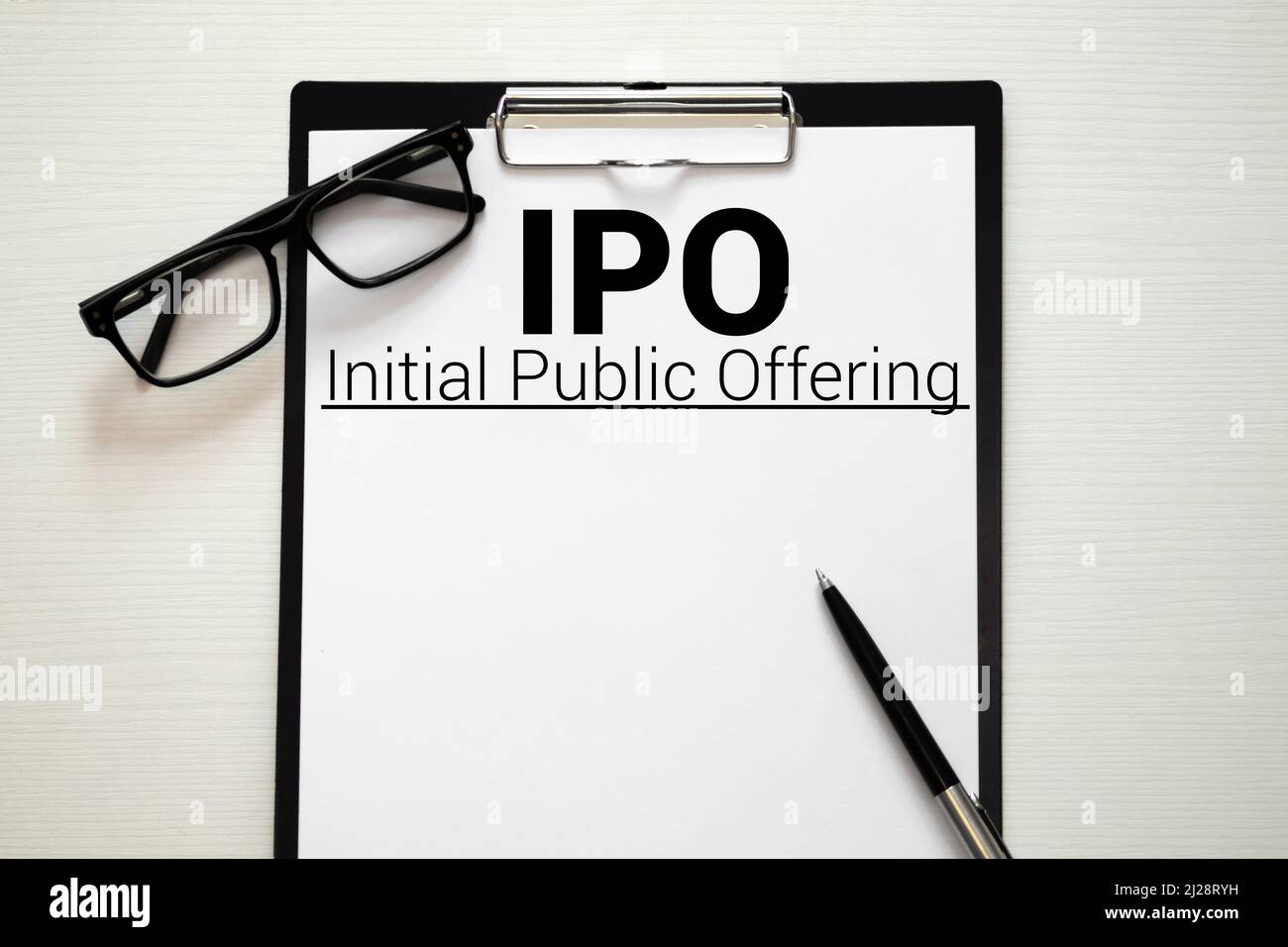 Sul tavolo ci sono rapporti finanziari, una penna, una lente d'ingrandimento e un notebook con l'iscrizione - IPO. Offerta pubblica iniziale. Affari e finanza Foto Stock