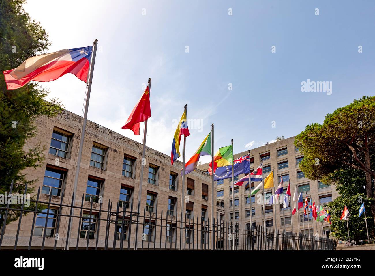 Roma, Italia - 1 agosto 2021: Bandiera delle Nazioni Unite e contese partecipanti con l'edificio delle Nazioni Unite a Roma. Foto Stock