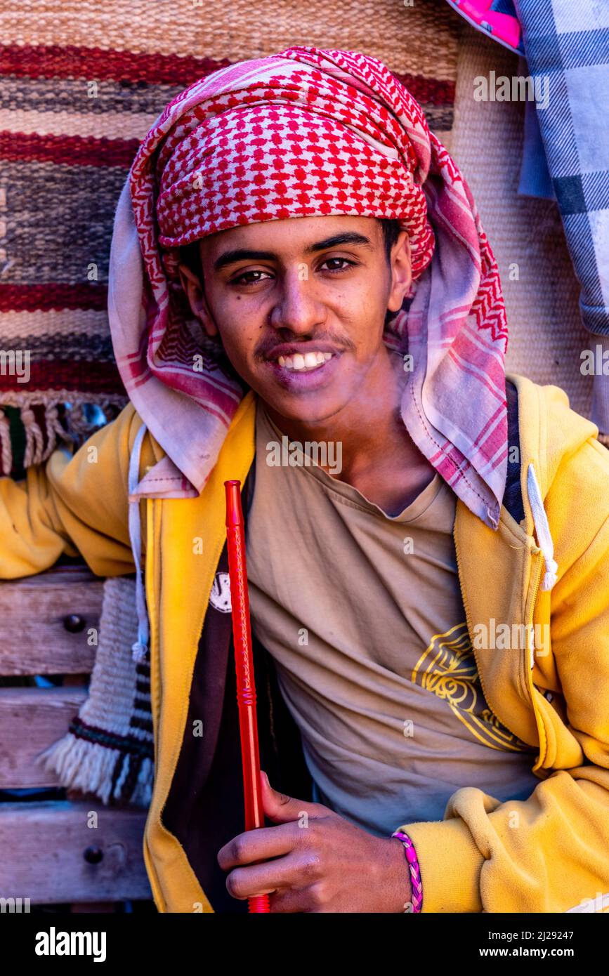 Un Ritratto di un giovane uomo che fuma Una pipa di Shisha, Petra, Giordania, Asia. Foto Stock