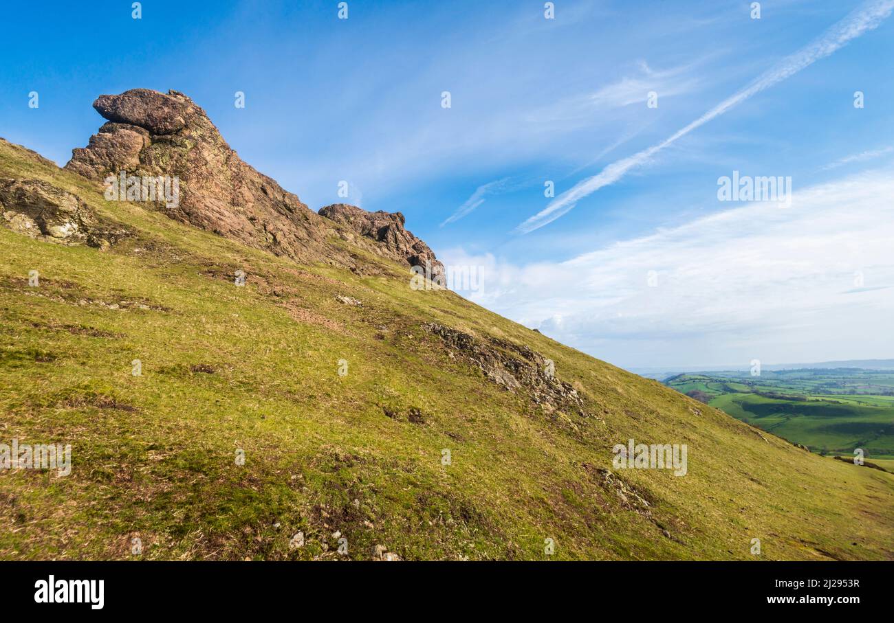 Rocce enormi che si affacciano sulla campagna dello Shropshire all'alba, paesaggio roccioso e colline coperte di erba, paesaggio suggestivo dalla collina ventosa. Foto Stock