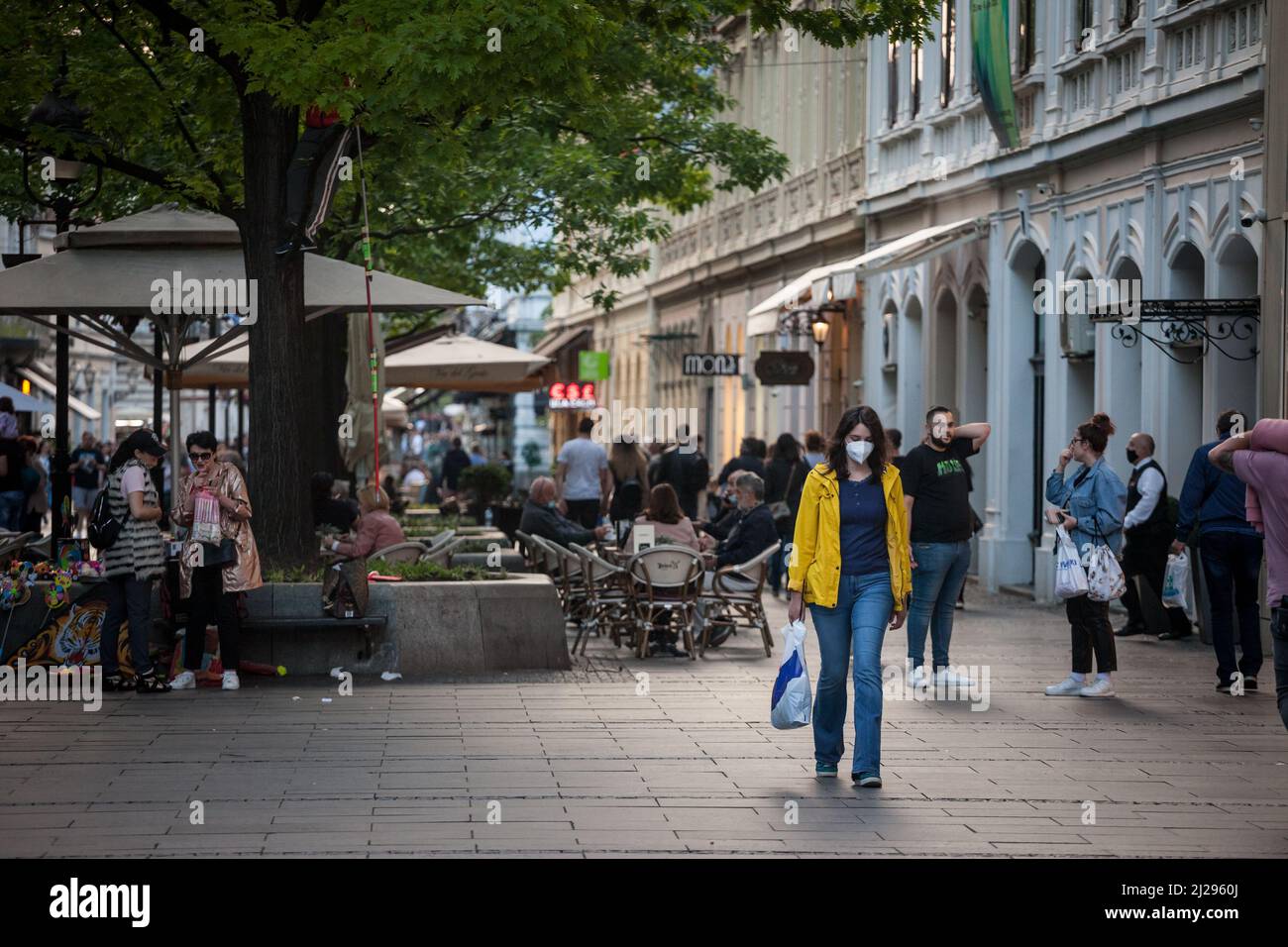 Foto di un bianco caucasico che cammina, giovane donna nelle strade di Belgrado, Serbia, indossando una maschera protettiva, durante il decor del 2020 Foto Stock