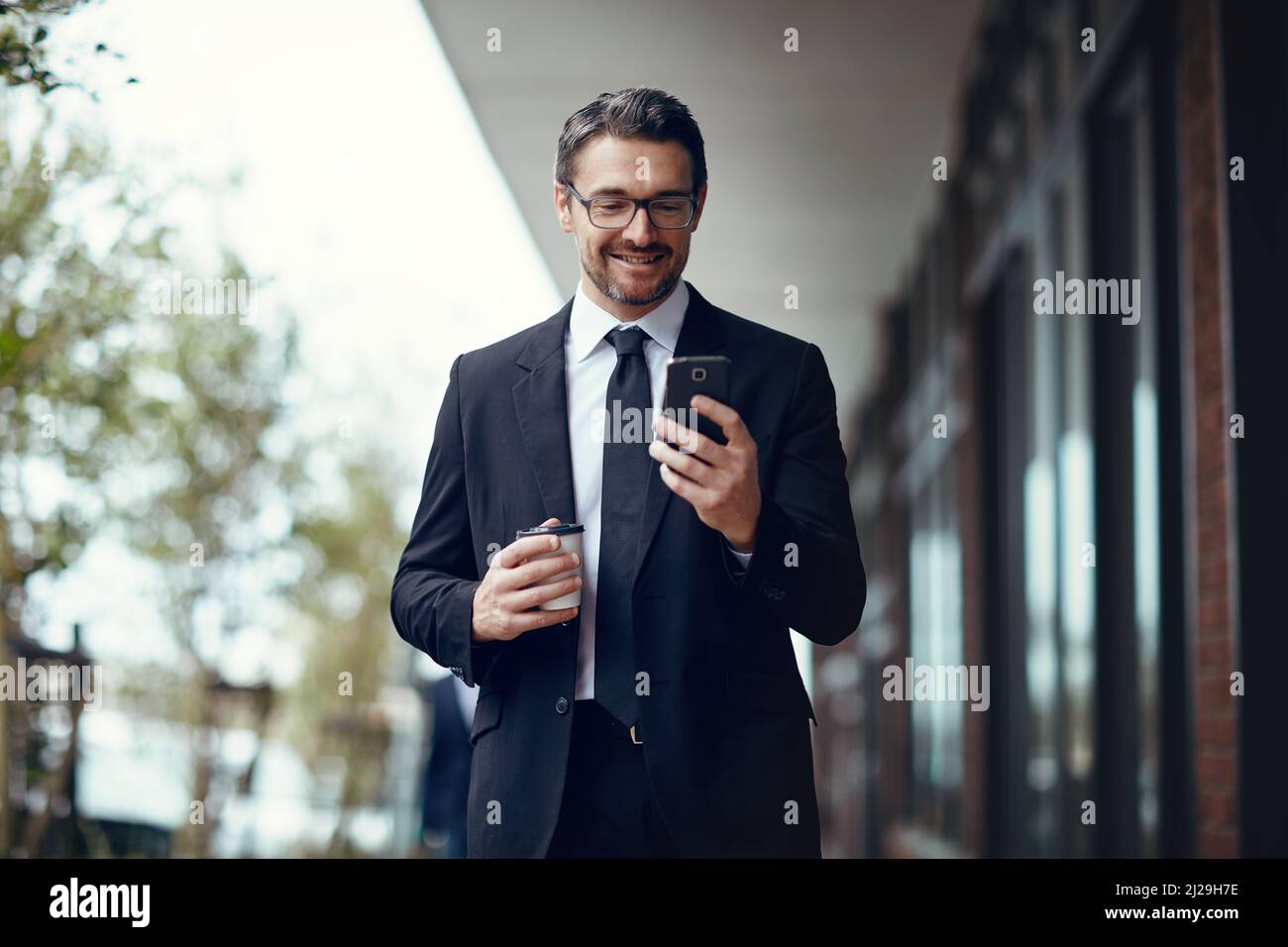 La flessibilità di lavorare in modalità wireless. Scatto di un uomo d'affari maturo che texting su un cellulare mentre fuori in città. Foto Stock