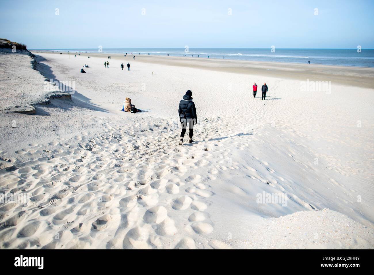 Norderney, Germania. 12th Mar 2022. Gli escursionisti camminano lungo la sezione della spiaggia 'Weiße Düne' vicino al bordo di break-off. Dopo le violente tempeste invernali con tempeste e notevoli perdite di sabbia, lo stato della bassa Sassonia vuole aiutare finanziariamente le isole frisone orientali colpite. (A dpa 'i sindaci dell'isola si affidano al rapido aiuto dello stato alla conferenza') Credit: Hauke-Christian Dittrich/dpa/Alamy Live News Foto Stock