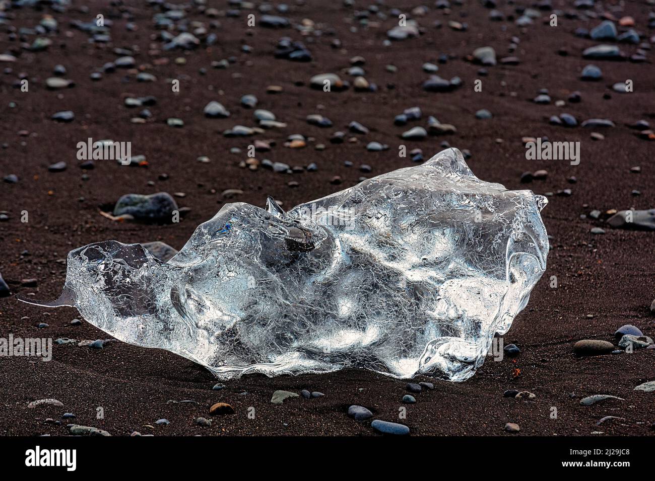 Iceberg fuso, cristallo di ghiaccio e ciottoli sulla spiaggia di lava nera, Spiaggia dei Diamanti, Joekulsarlon, Parco Nazionale Vatnajoekull, Islanda sudorientale, Islanda Foto Stock