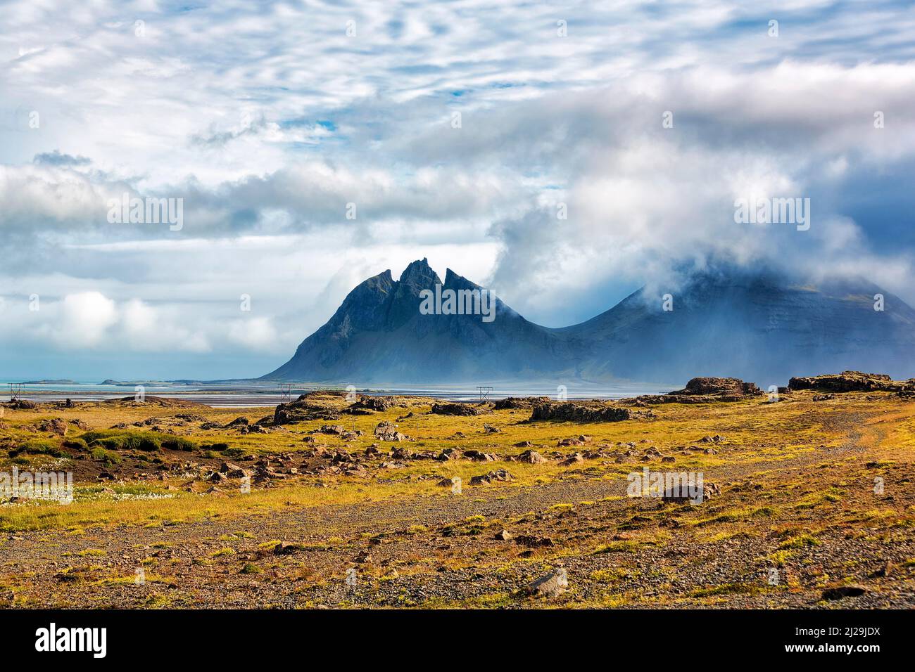 Montagna frastagliata Brunnhorn, chiamato montagna Batman, catena montuosa Klifatindur in estate, Islanda orientale, Islanda Foto Stock