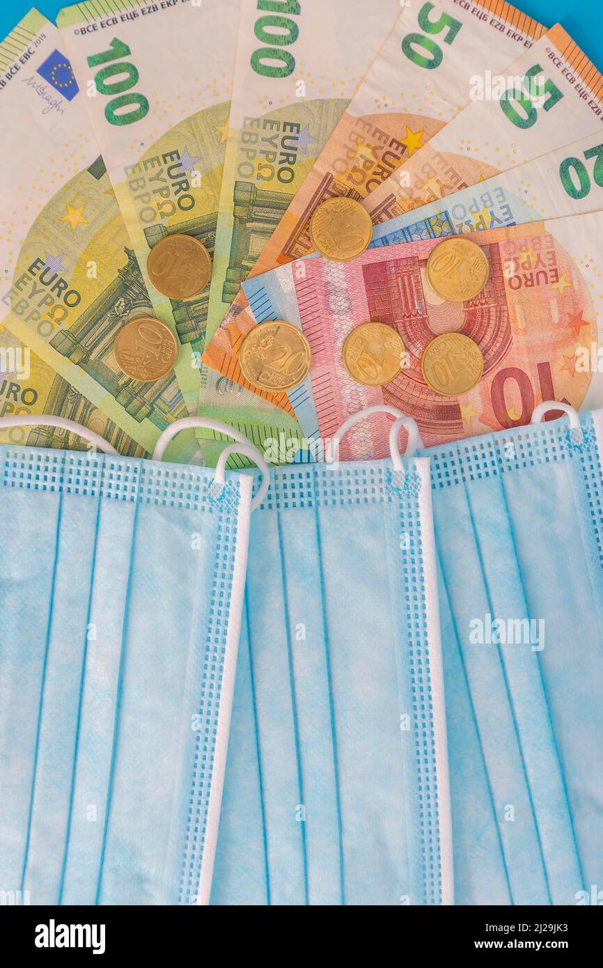 Maschere mediche e banconote in euro. Crisi finanziaria dovuta alle perdite di Coronavirus, focus selettivo Foto Stock