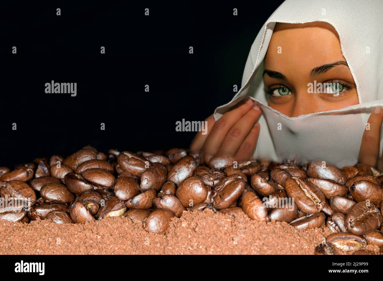 I chicchi di caffè della varietà arabica si trovano sul caffè macinato, sullo sfondo una giovane donna araba con velo Foto Stock