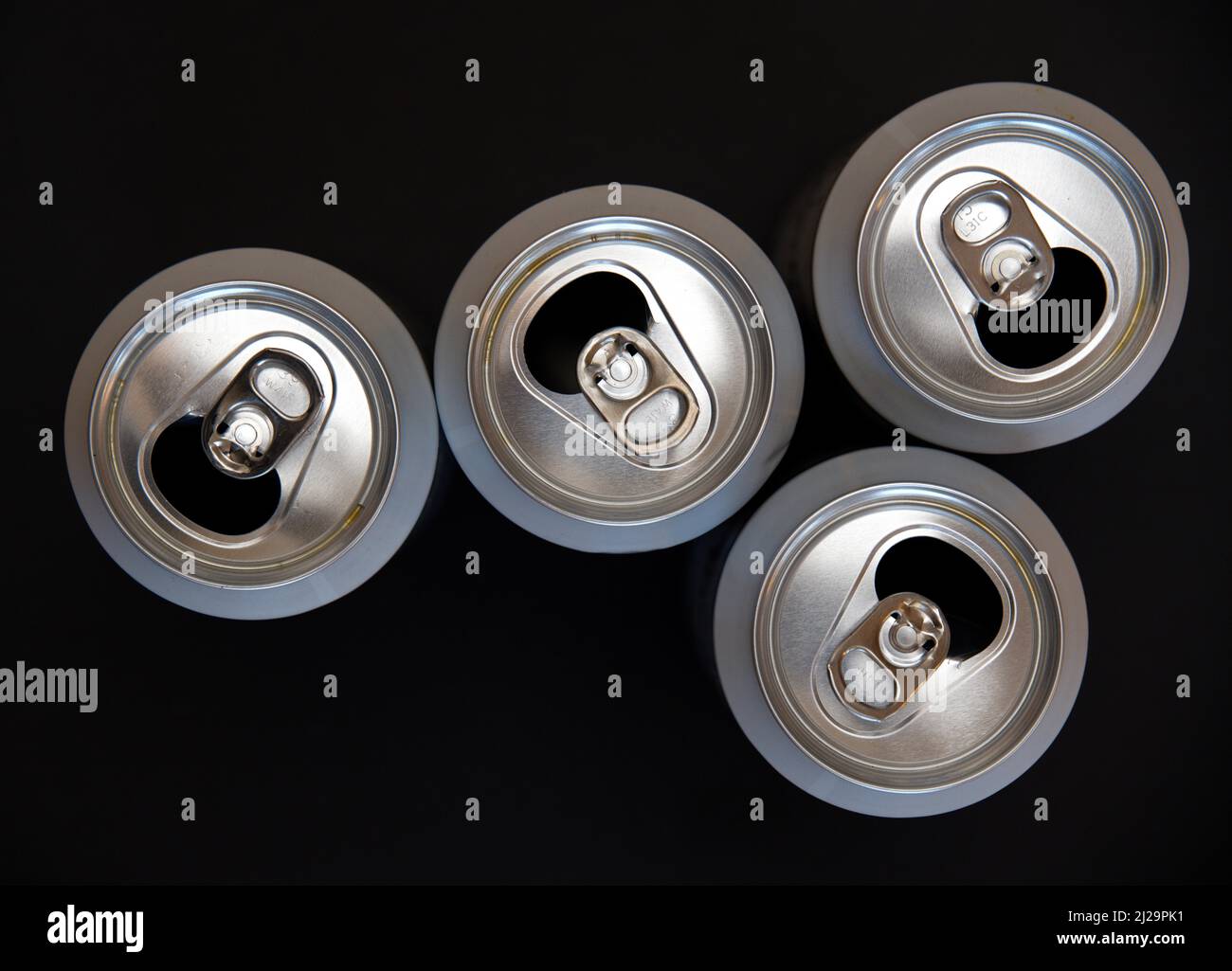 Quattro lattine di birra aperte e vuote su sfondo nero Foto Stock