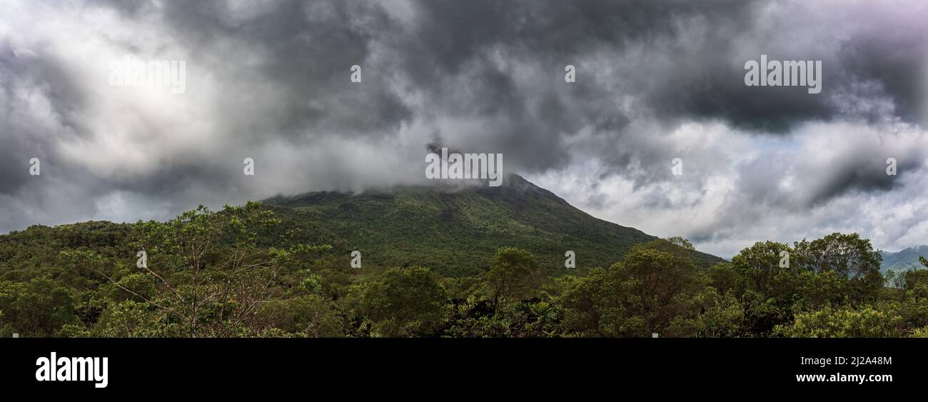 Vulcano Arenal immerso nelle nuvole sullo sfondo. Provincia di la Fortuna, Costa Rica.Volcano paesaggio. Foto Stock