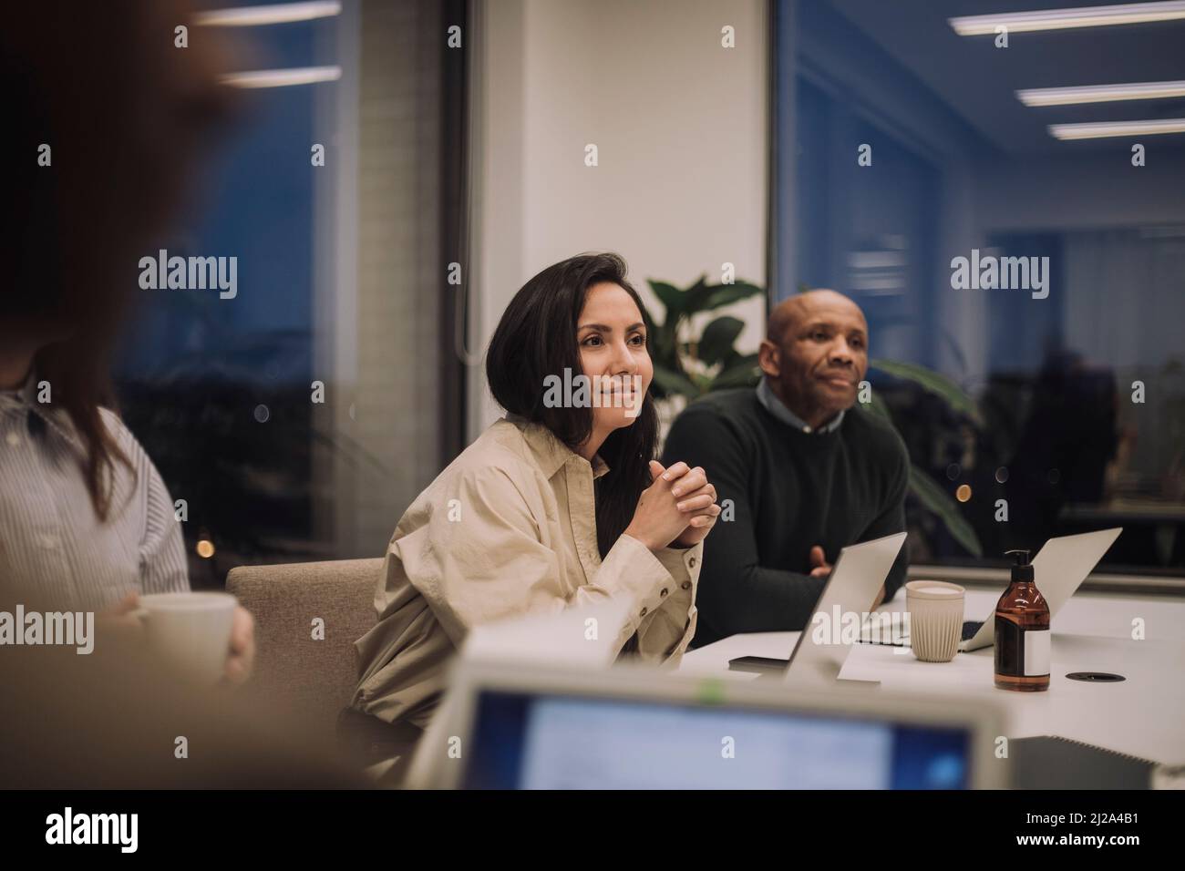 Donna d'affari con colleghi di sesso maschile e femminile che discutono in riunione in ufficio Foto Stock