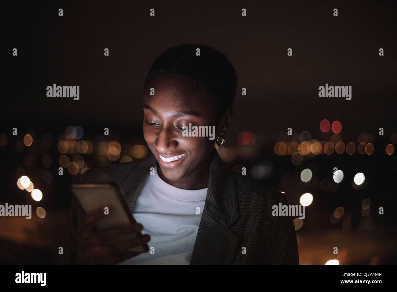 Felice uomo d'affari messaggi di testo su smartphone di notte Foto Stock