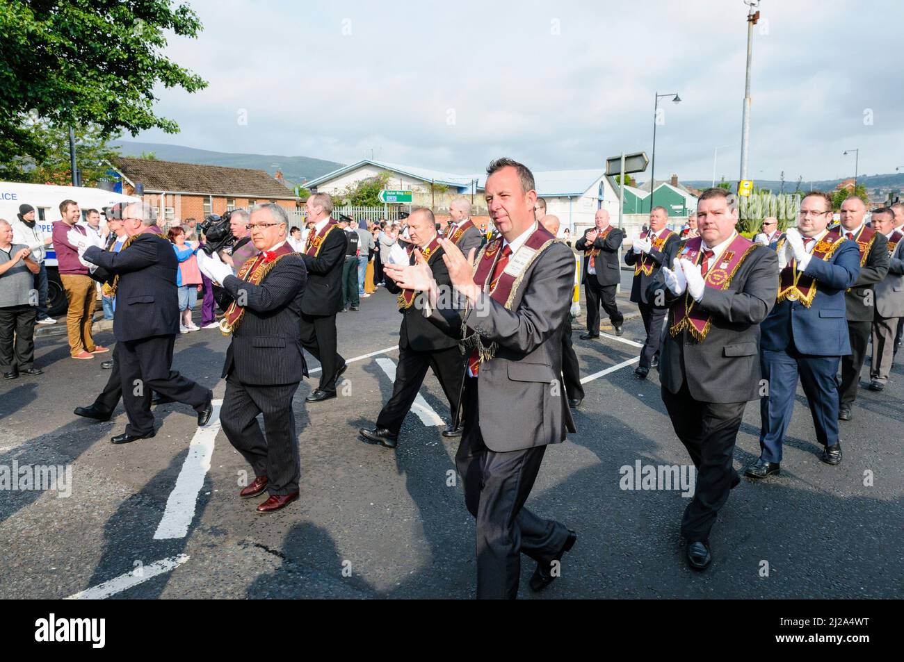 11th agosto 2012, Belfast. Gli apprendisti dei membri del Derry Lodge applaudono i loro sostenitori mentre sfilano davanti ai manifestanti di Ardoyne. Foto Stock