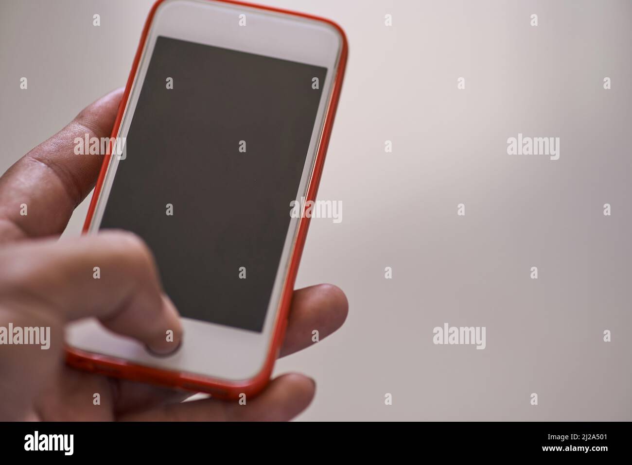 Una mano che tiene uno smartphone Foto Stock