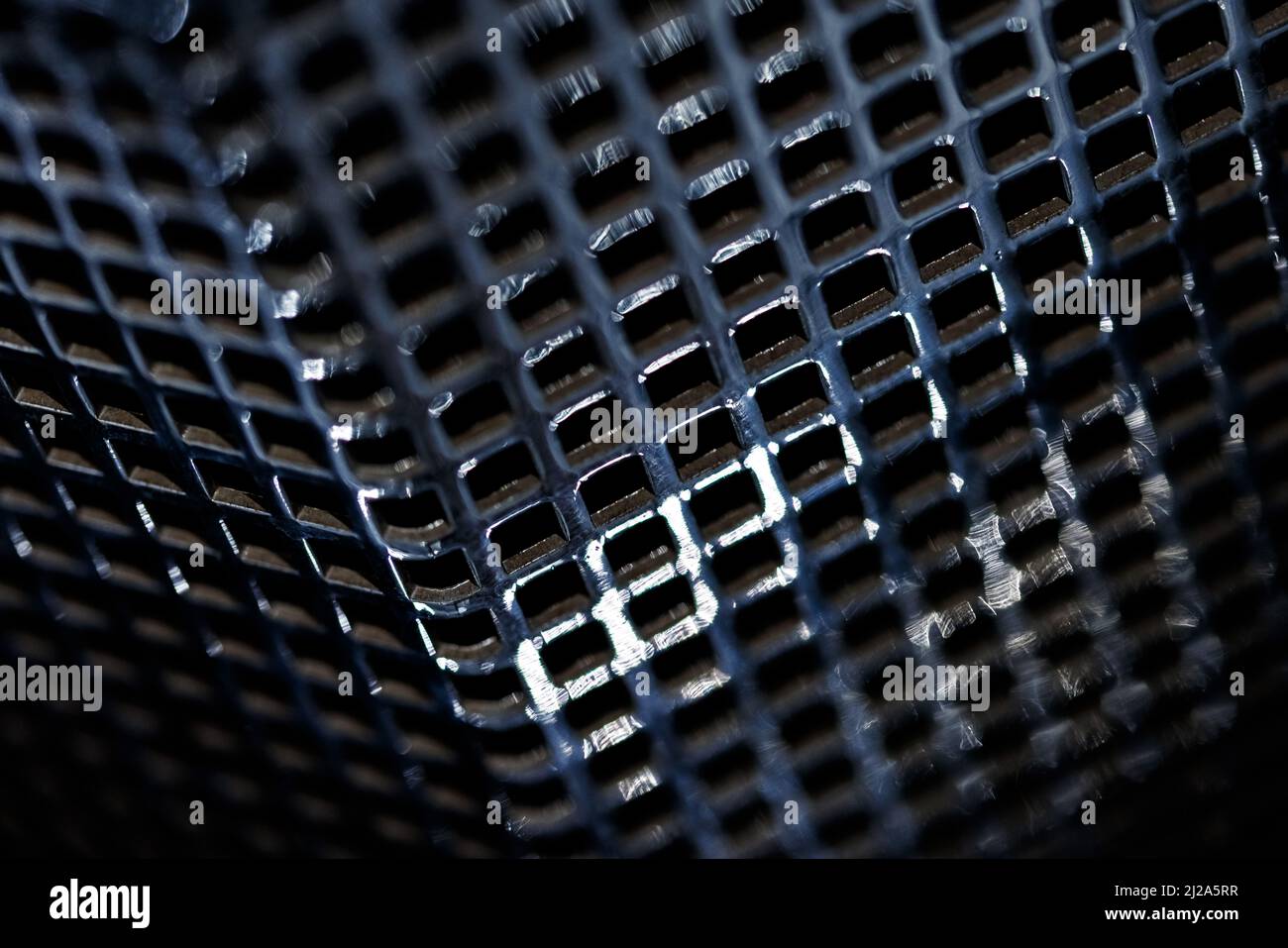 Vista prospettica su griglia in metallo cromato con messa a fuoco selettiva. Piccola profondità di campo. Foto Stock