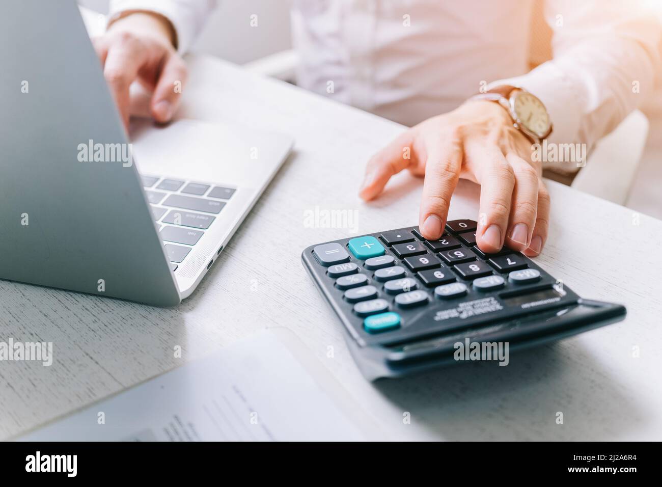 Gli uomini d'affari asiatici usano una calcolatrice per calcolare le tasse ed il reddito Foto Stock