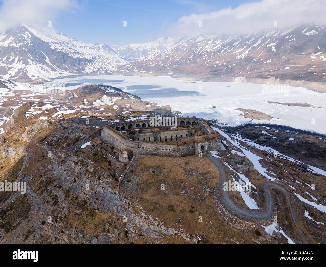 Vista aerea di antiche rovine fortilizio in montagna vicino al lago ghiacciato e diga Foto Stock