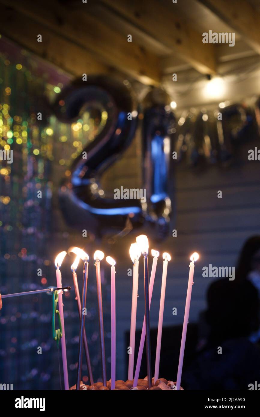 Una torta con alte candele accese in forma di palloni di elio per una festa di 21st anni. Foto Stock