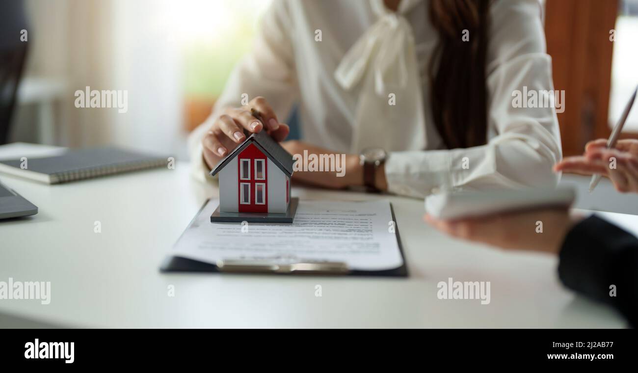 Agente immobiliare o ufficiale di banca descrive l'interesse di prestito al cliente con i contratti di acquisto della casa o sui prestiti di ufficio e sui tassi di interesse Foto Stock