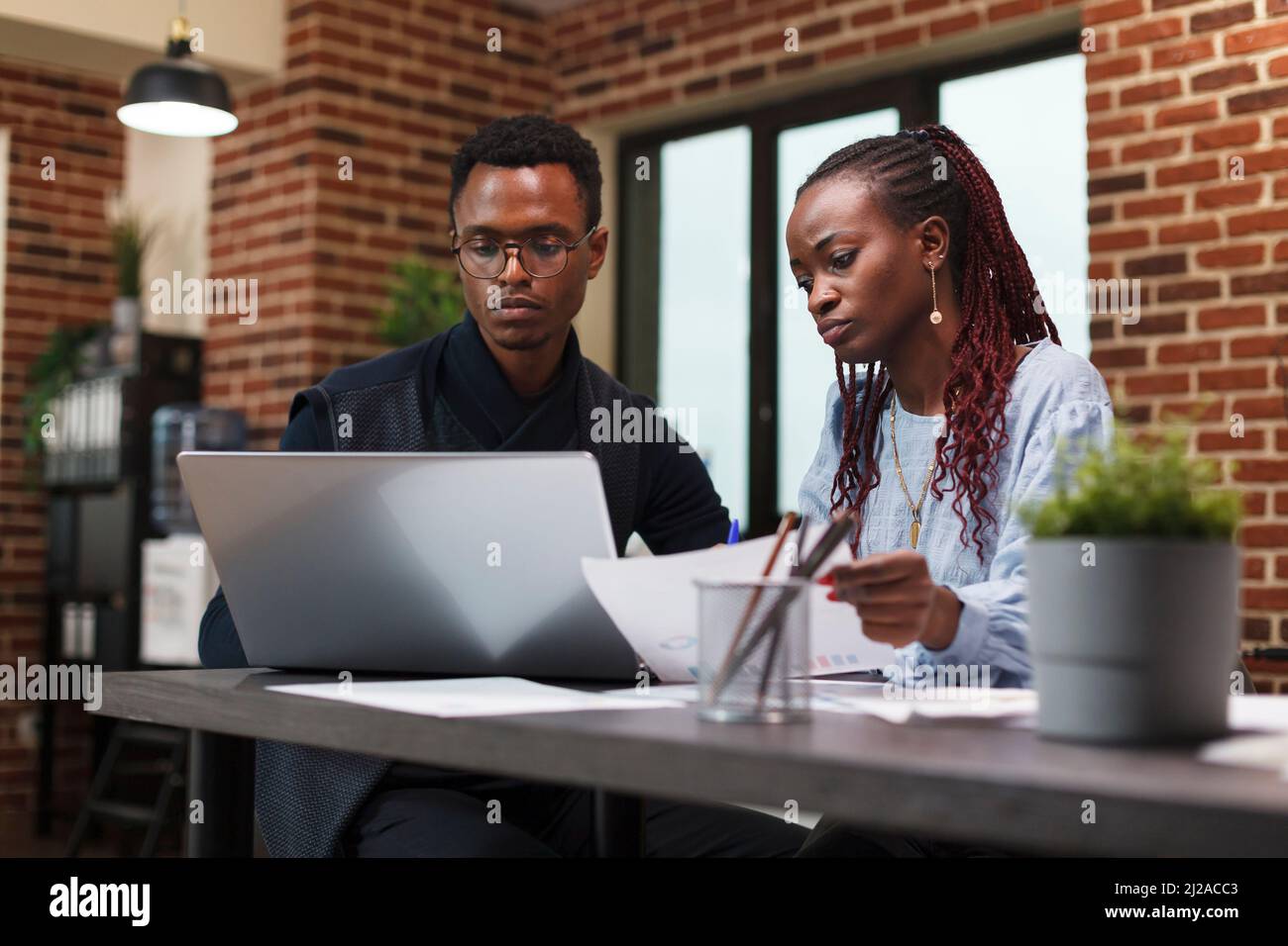 Azienda african american colleghi in riunione sullo stato finanziario del progetto di avvio. Il personale di affari alla scrivania nel reparto finanziario dell'ufficio dell'agenzia che parla delle spese di vendita. Foto Stock