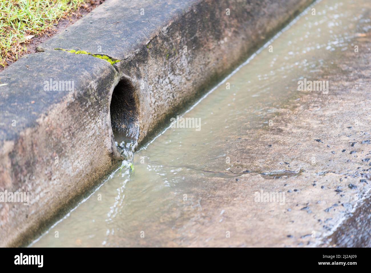 Un'uscita di drenaggio di acqua piovana residenziale dopo una pioggia intensa con acqua che scorre nel grondatoio e dal drenaggio a Sydney, nuovo Galles del Sud, Australia Foto Stock