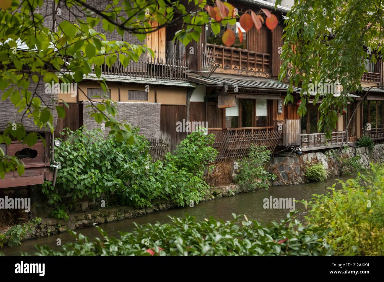 Vista orizzontale di alcune tradizionali case di legno sulla riva del fiume Shirakawa a Gion, nel distretto meridionale di Higashiyama, Kyoto, Giappone Foto Stock