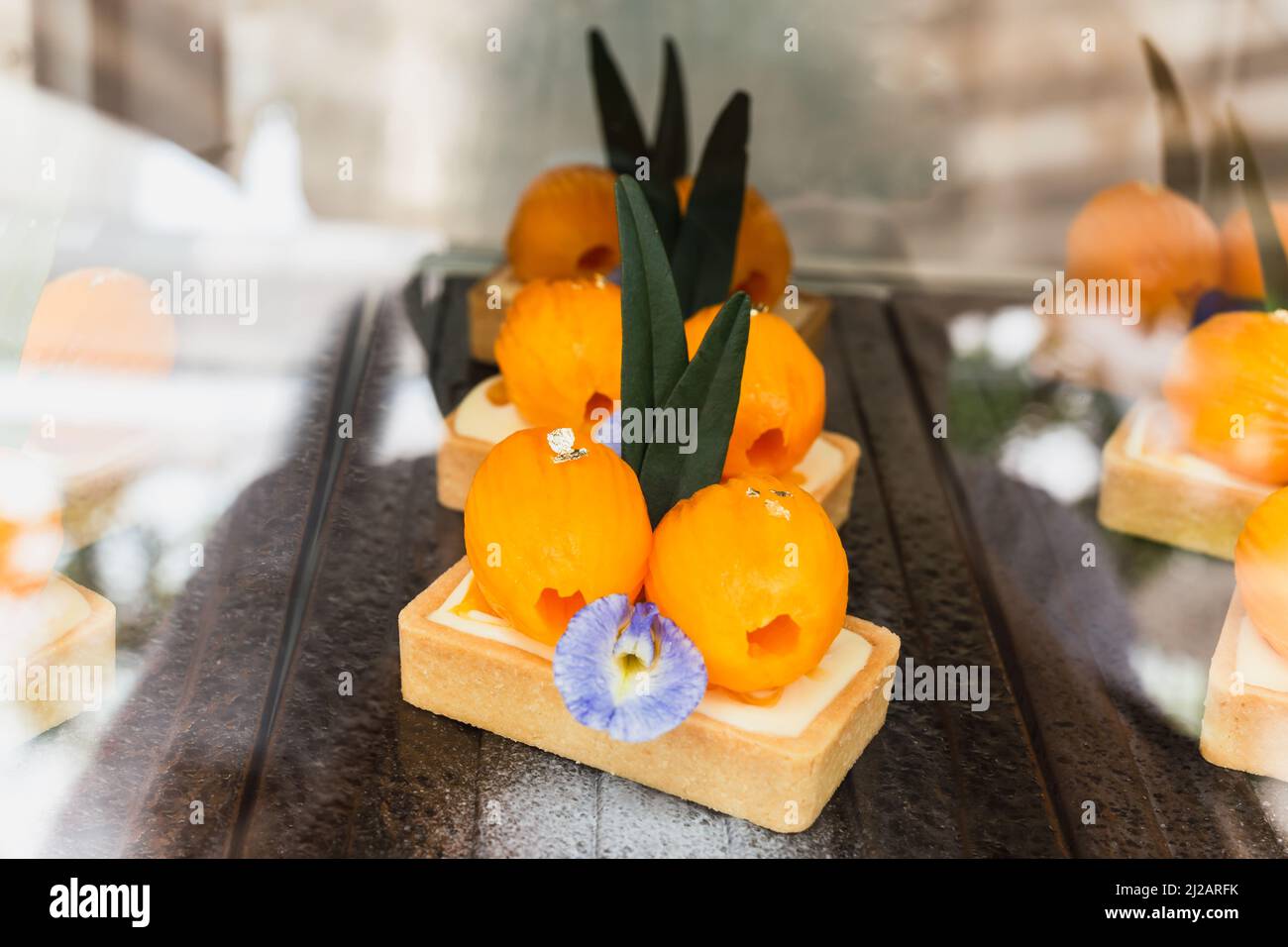 Torta al formaggio decorata con prugna mariana in vendita nel frigorifero in caffetteria. Foto Stock