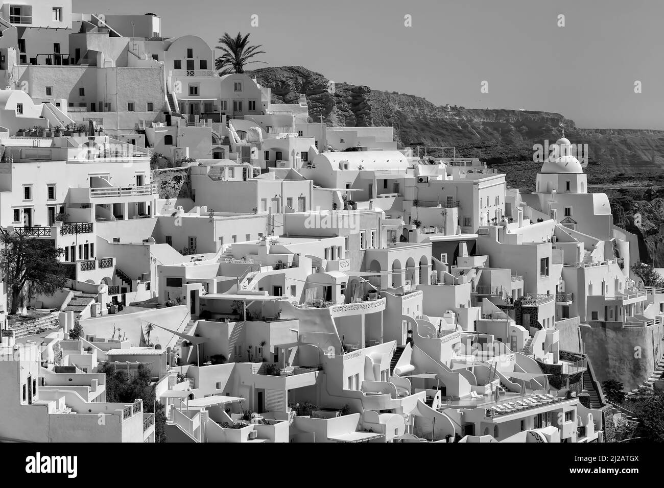 Vista panoramica del pittoresco villaggio di Fira Santorini con i suoi hotel, ristoranti e ville in bianco e nero Foto Stock