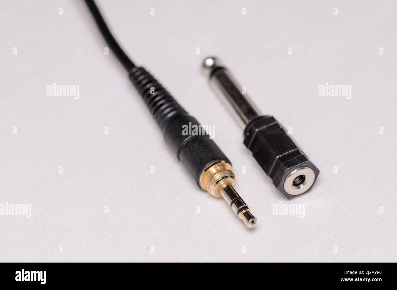 connettore jack per cuffie stereo 3,5mm e convertitore 6,3mm per segnali audio analogici su sfondo bianco Foto Stock