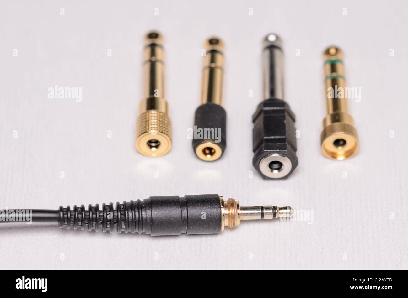 connettore jack per cuffie stereo 3,5mm e molti convertitori 6,3mm per segnali audio analogici su sfondo bianco Foto Stock