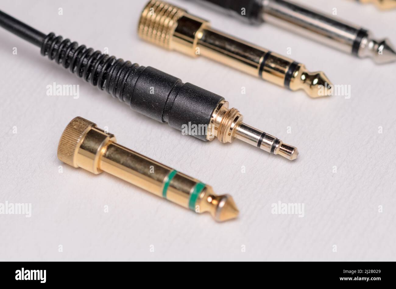 connettore jack per cuffie stereo 3,5mm e molti convertitori 6,3mm per segnali audio analogici su sfondo bianco Foto Stock