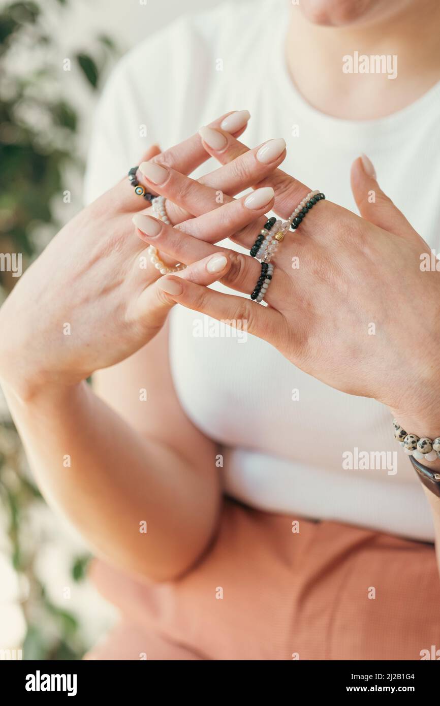 Giovane donna con bellissimi accessori per le mani, anelli fatti a mano da vicino Foto Stock