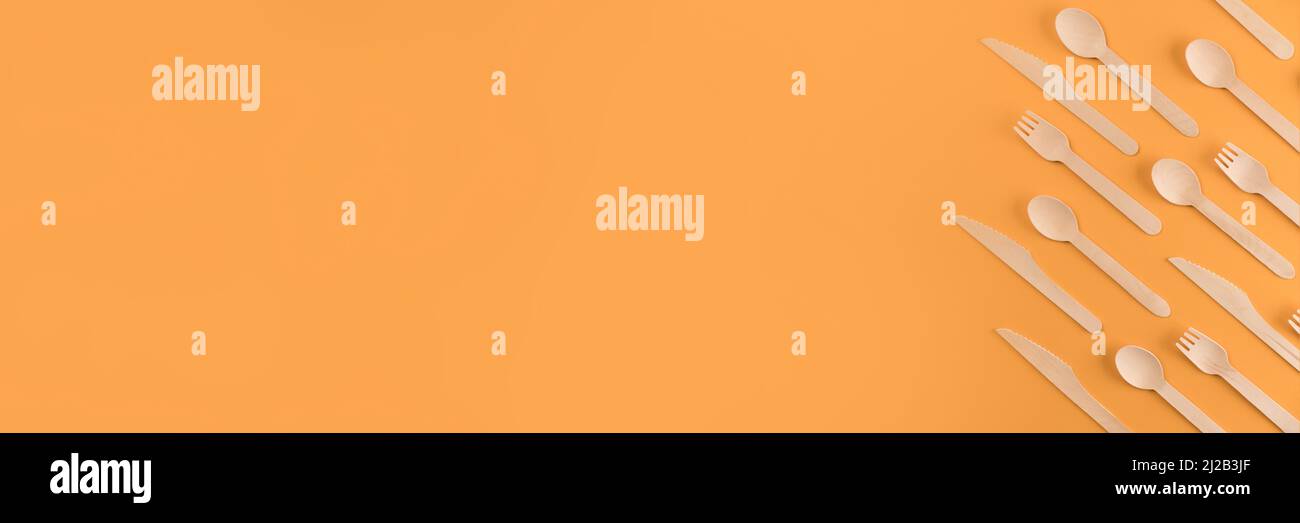 Banner con posate in legno di bambù - concetto di posate biodegradabili e componibili. Posate di bambù su sfondo arancione con spazio copia. Ambientatori Foto Stock