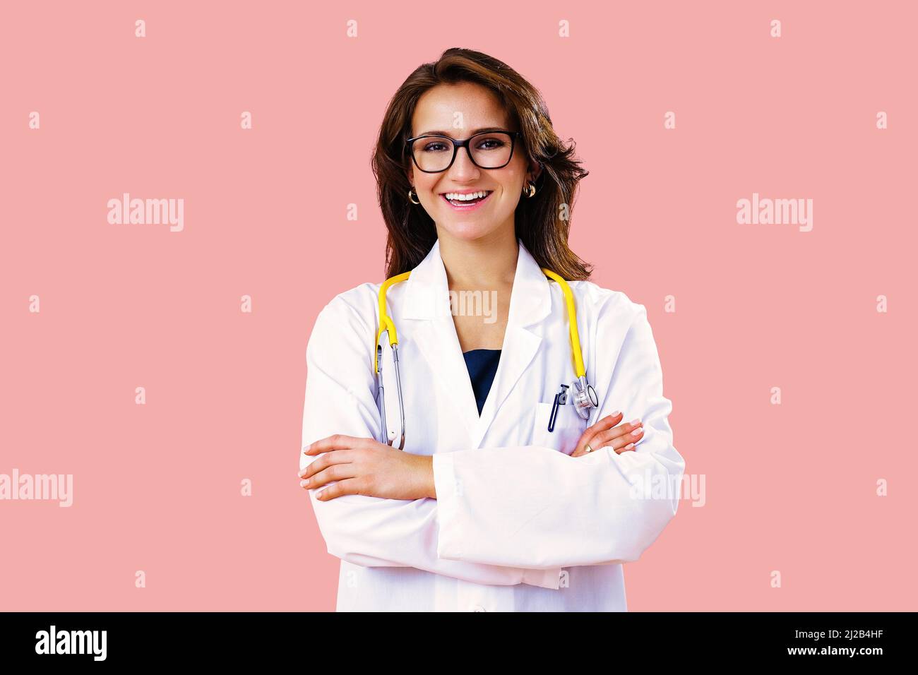 Ritratto di sorridente medico in occhiali con braccia incrociate su sfondo rosa studio assistenza sanitaria Foto Stock