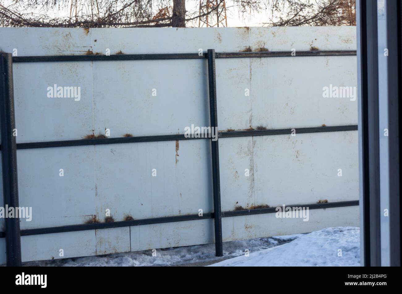 Recinzione grigia con elementi di ruggine e disegni. Foto Stock