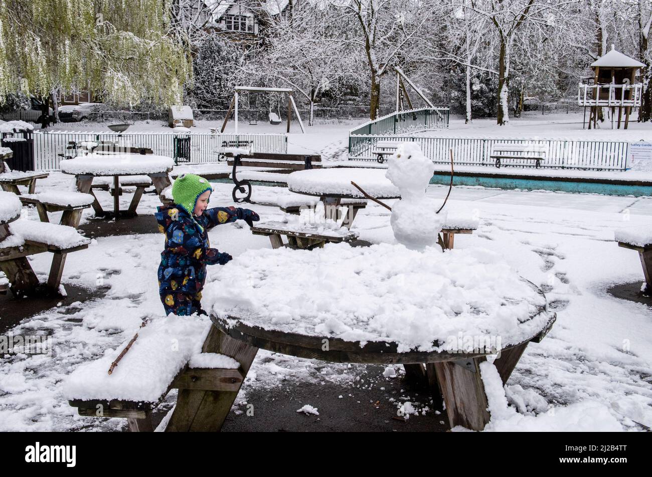 Harrogate, Regno Unito. 31st Mar 2022. Più neve a Harrogate oggi dopo il bel tempo caldo della settimana scorsa. Gaby, 4 anni, con il pupazzo di neve che ha appena fatto con la mamma nei giardini della valle. Picture Credit: ernesto Rogata/Alamy Live News Foto Stock
