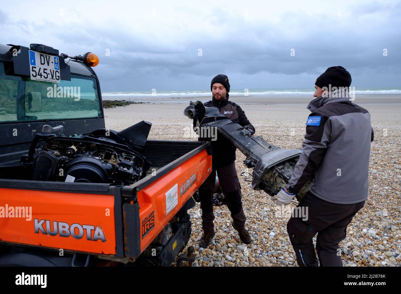 Rifugiati e migranti nella regione degli Hauts-de-France (Francia settentrionale), il 26 novembre 2021: Lavoratori del consiglio che rimuovono pezzi di una barca e di un motore b Foto Stock