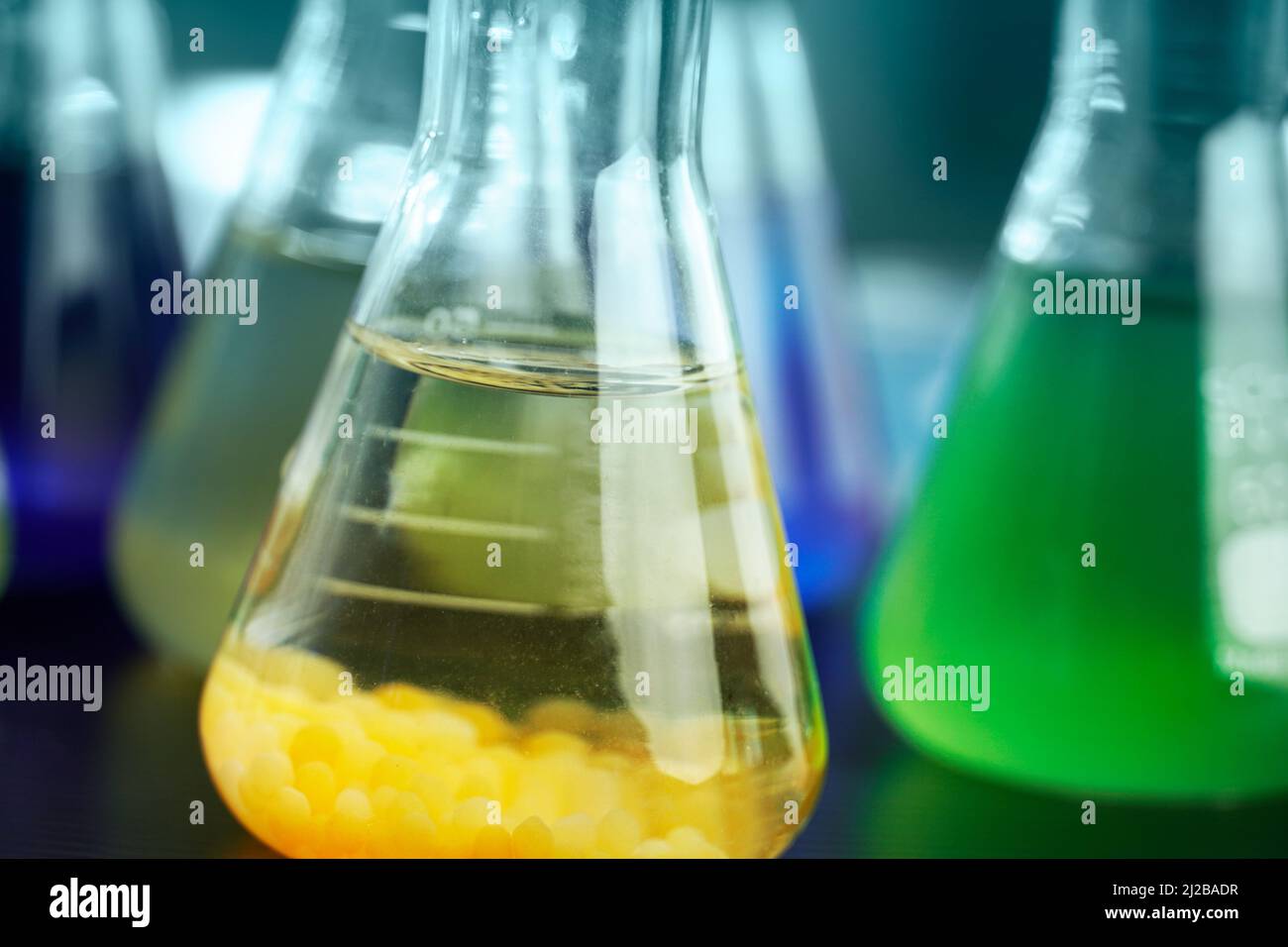 soluzione arancione e verde in matraccio di vetro scientifico presso il laboratorio di ricerca chimica Foto Stock