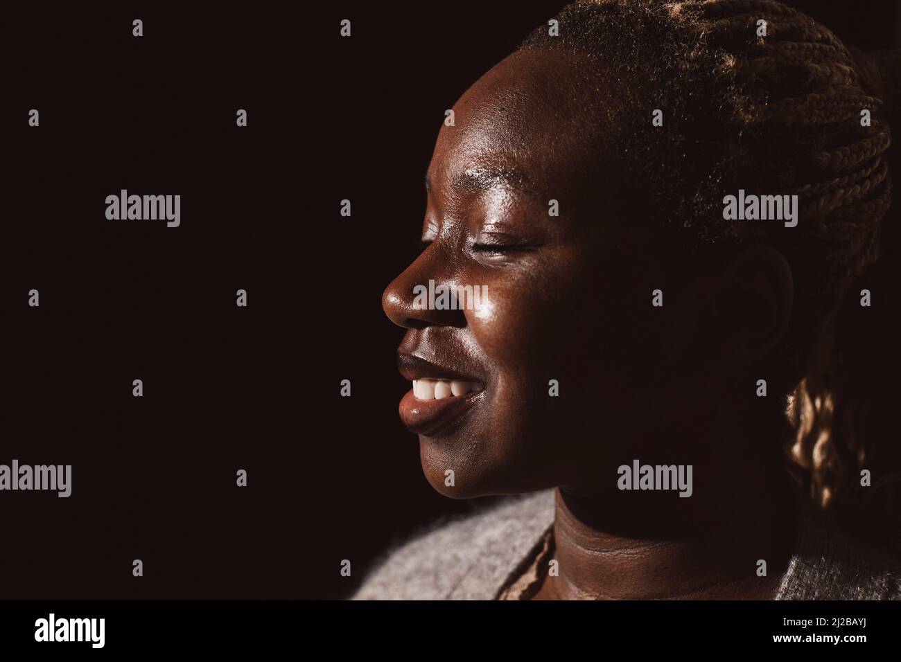 Donna sorridente con occhi chiuso giorno sognando in studio Foto Stock