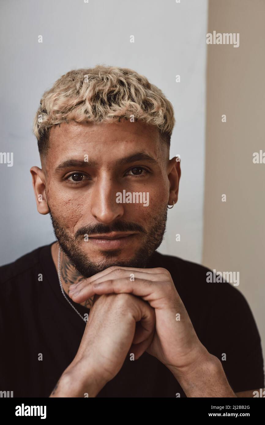 Ritratto del giovane uomo con mano sul mento in studio Foto Stock