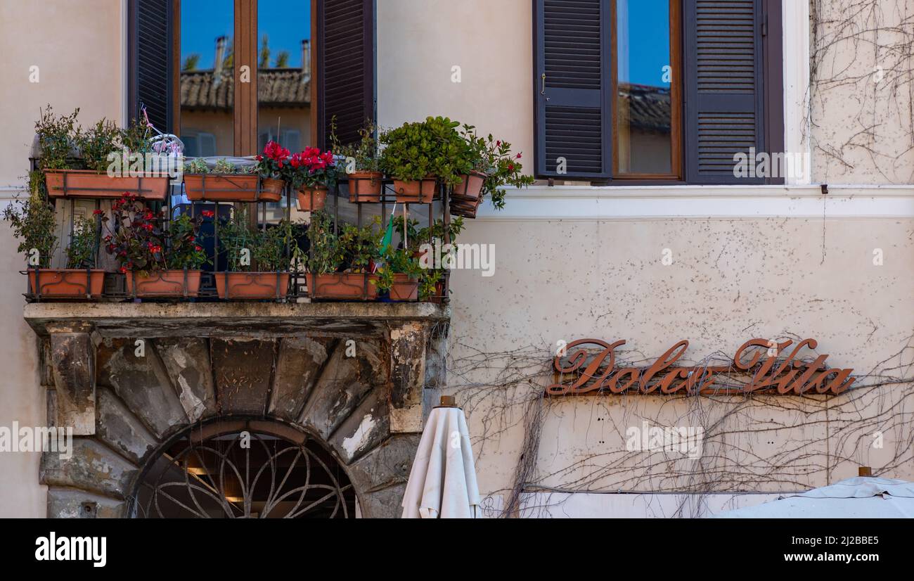 Una foto di un balcone a pianta di Roma accanto al segno della famosa espressione italiana Dolce vita. Foto Stock