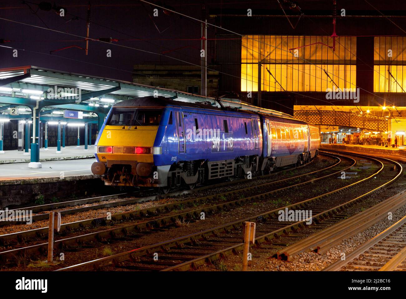SKY livrea East Coast classe 91 locomotiva elettrica 91125 alla stazione ferroviaria di Carlisle con un treno diretto dirottato East Coast Foto Stock