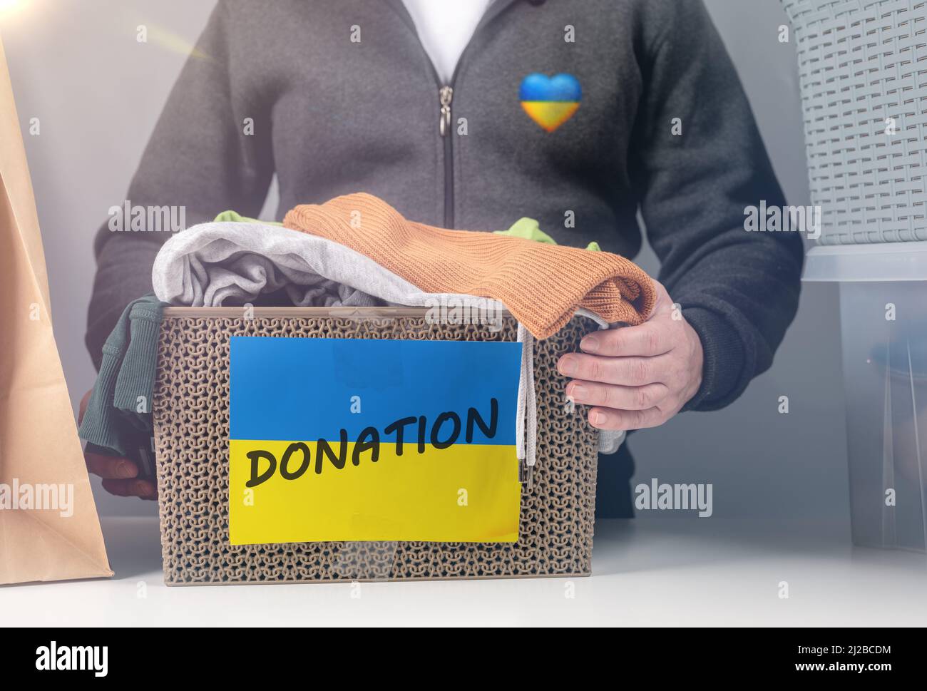 Raccoglie le donazioni di vestiti per i rifugiati ucraini, il sostegno all'ucraina, gli aiuti umanitari. Scatola con abiti da donazione per i rifugiati ucraini che soffrono f Foto Stock