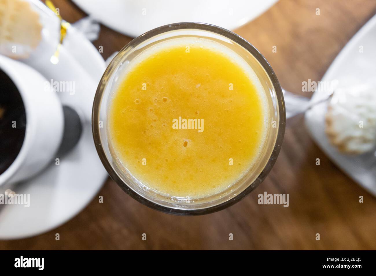 ampia prospettiva di tavolo con vetro cristallo con succo d'arancia naturale, frutta biologica e rinfrescante, tavolo da ristorante, menu Foto Stock