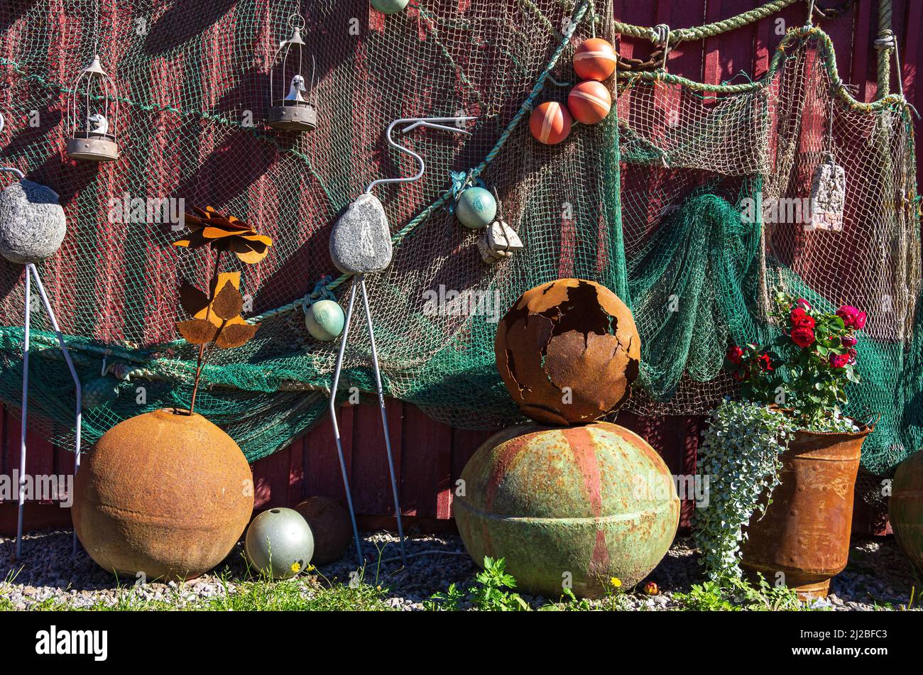 Oggetti marittimi scartati e attrezzature come boe arrugginite e vecchie reti da pesca esposte sulla parete di legno di un capannone, Nordkoster, Svezia. Foto Stock