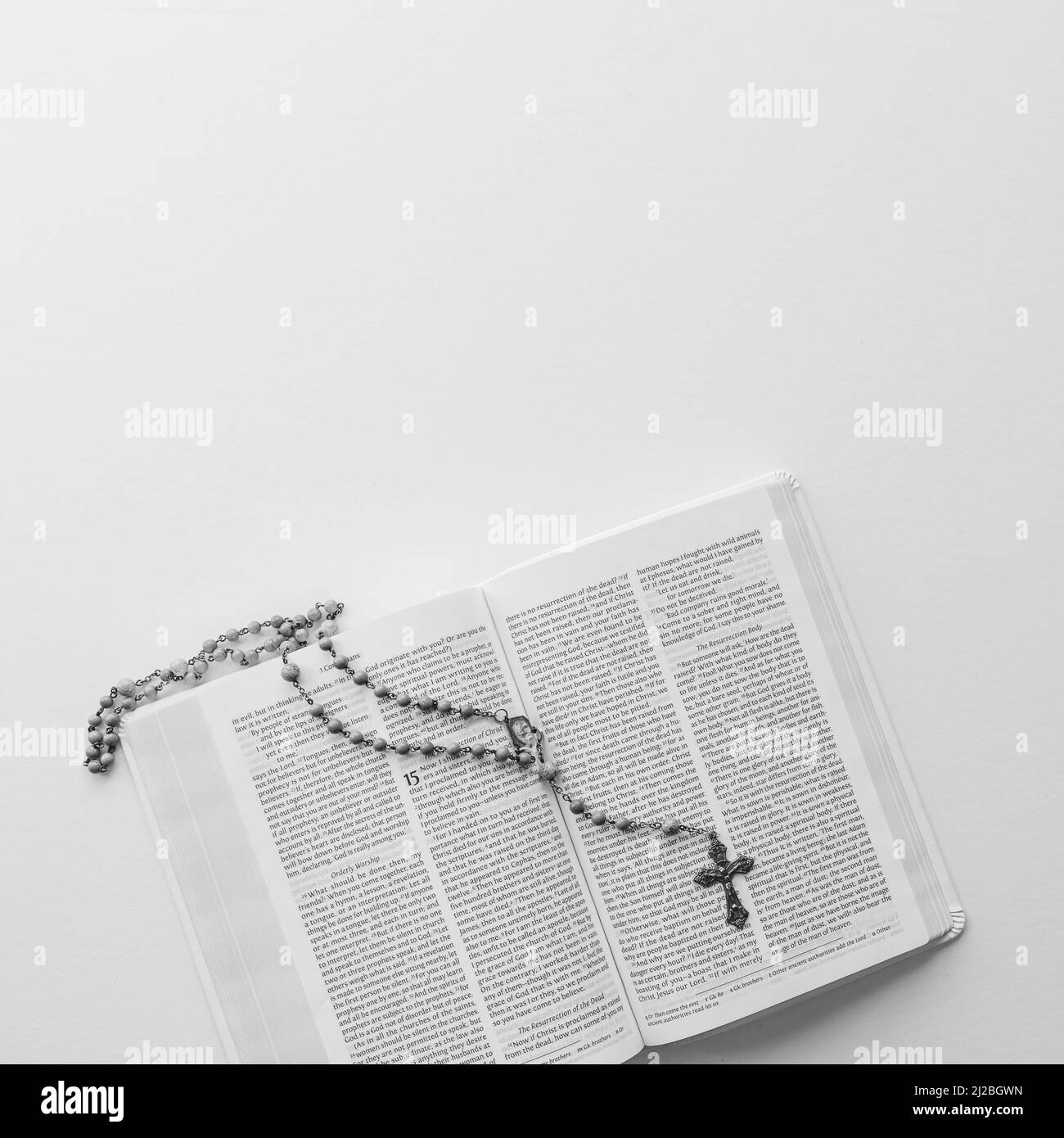 Perle di preghiera cattoliche del Rosario che si stendano su una bibbia aperta con spazio per la copia Foto Stock