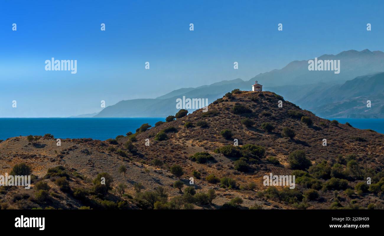 Piccola cappella sulla cima di una collina vicino Agios Pavlos, Creta con il mare alle spalle Foto Stock