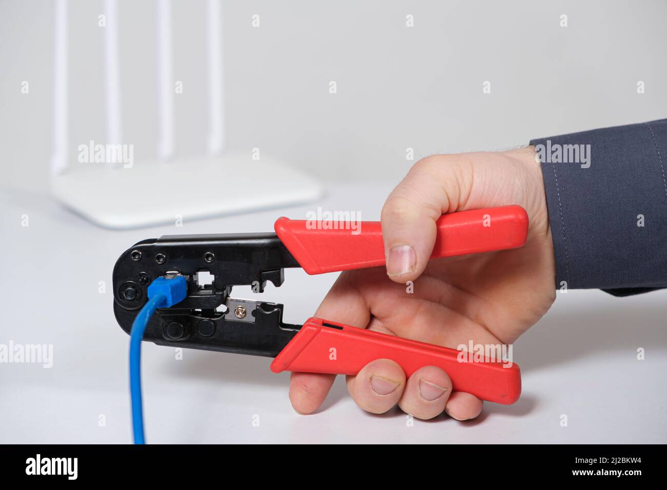 Il master del computer stabilisce la connessione del connettore VLAN con un attrezzo speciale crimpatore. Foto Stock