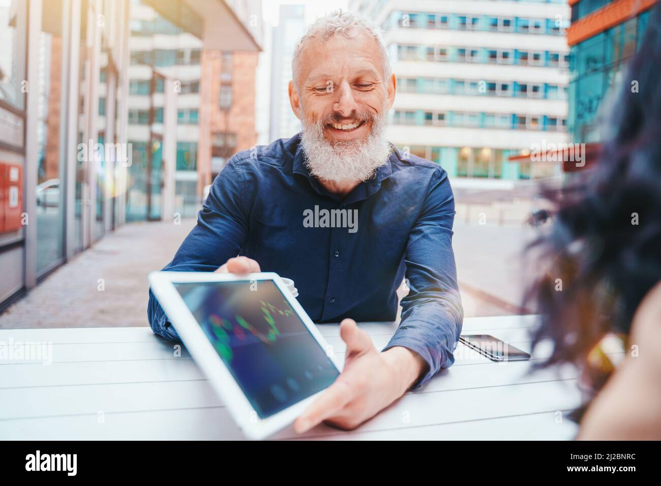 Businessman mostra il grafico del mercato azionario di negoziazione su un tablet Foto Stock