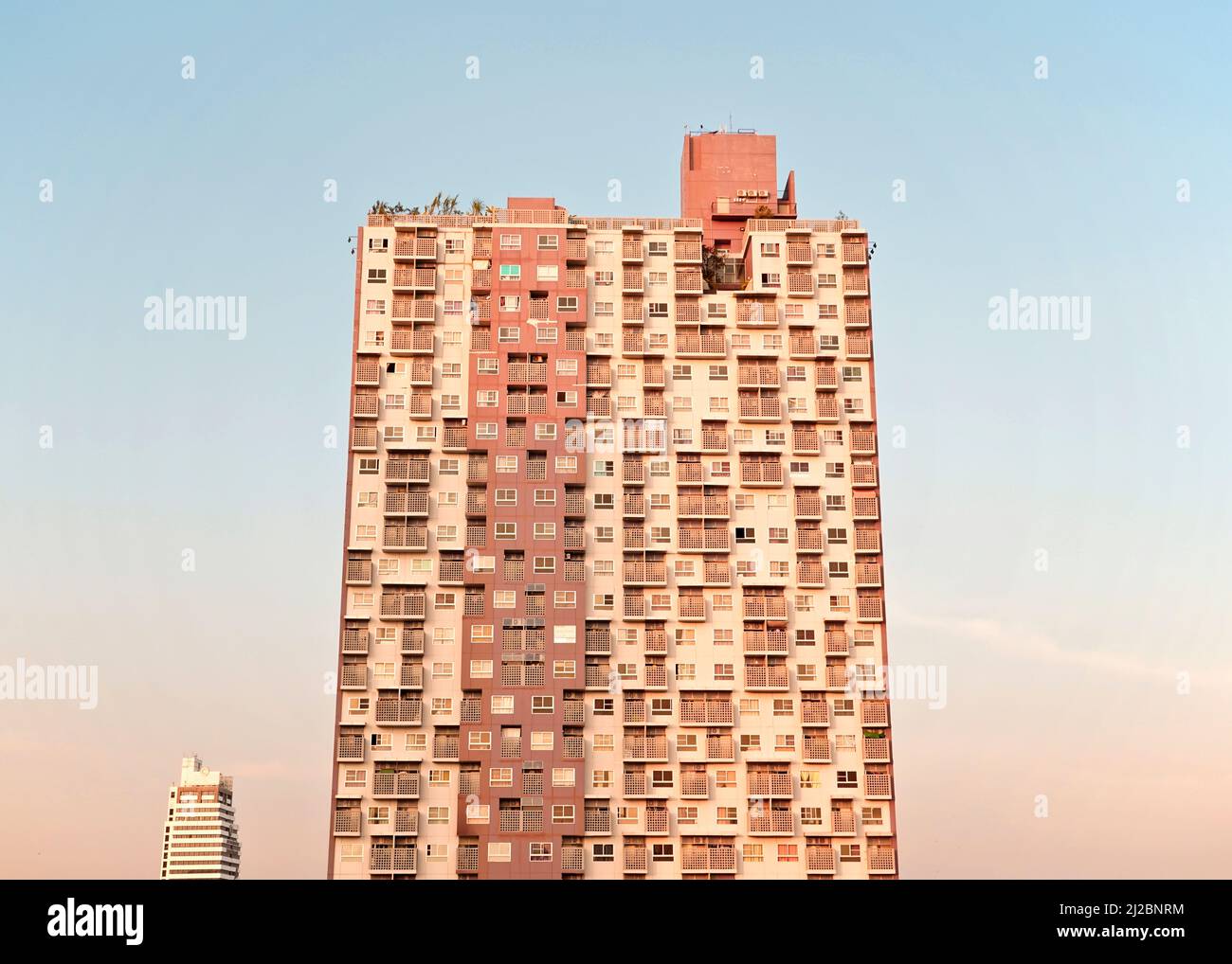 Alto edificio urbano marrone, tonalita' terrene, moderno edificio cosmopolita e cosmopolita a ridosso di uno splendido skyline di colore blu pastello. Foto Stock