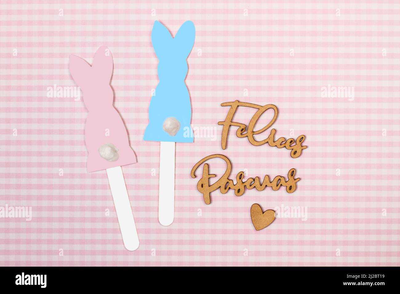 Profilo di coniglio di carta blu e rosa e parola di Felices Pascuas in lettera di legno scritta a mano (buona pasqua) Foto Stock
